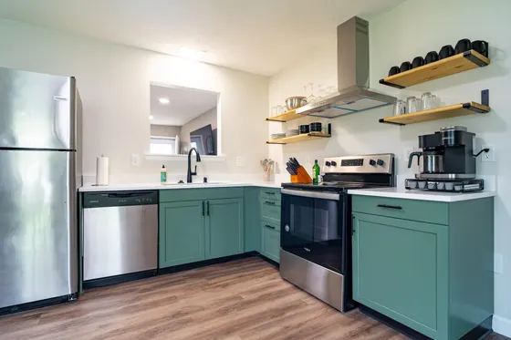 Kitchen with teal-green cabinets and stainless-steel appliances.