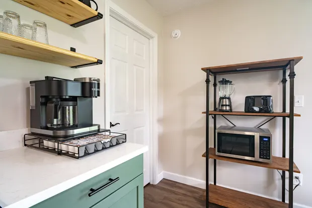 Coffee bar with a drip maker and shelving.