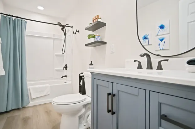 Full bathroom with a tub and shower, open shelving, and a vanity.