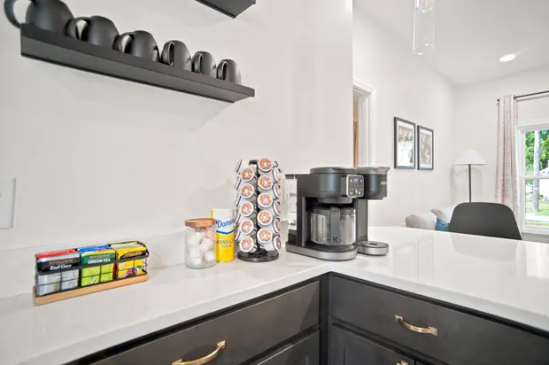 Kitchen island with seating and a coffee bar along the counter.