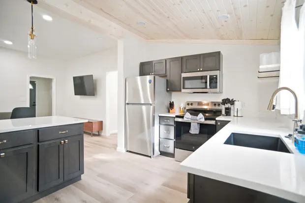 Kitchen with a prep island, microwave, and stainless refrigerator.