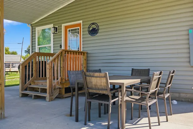 Covered front patio with a dining table and chairs.