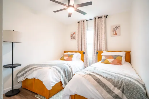 Bedroom with two twin beds and orange accents.