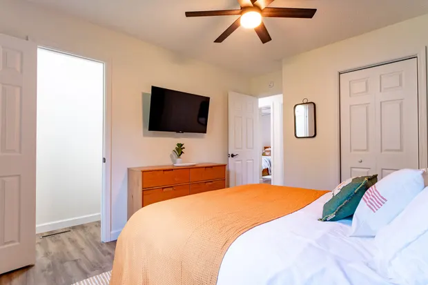 King bedroom with a mounted smart TV and a dresser.