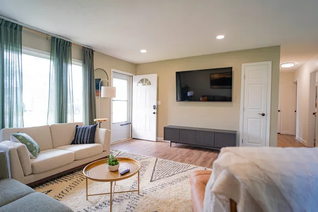 Bright living room with a beige sofa and a wall-mounted TV.