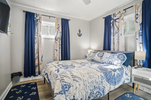 Main-floor bedroom with a queen bed, nautical blue bedding, and anchor decor.