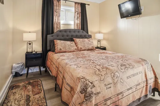 Second main-floor bedroom with a queen bed and a treasure-map bedspread.