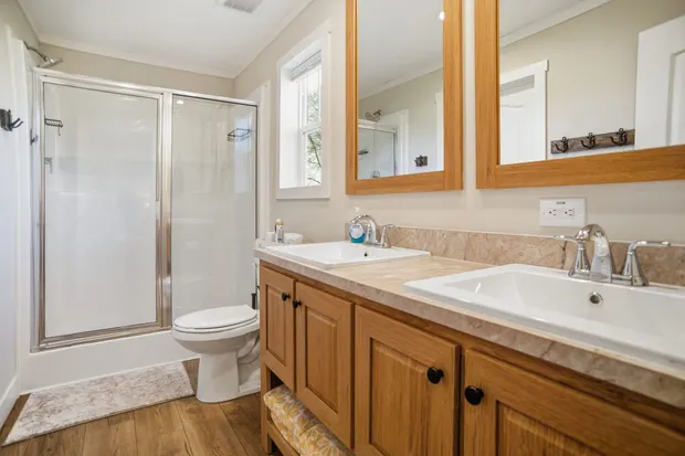 Ensuite bathroom with double vanities and a glass walk-in shower.