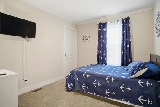 Third bedroom with nautical anchor bedding and a wall-mounted TV.