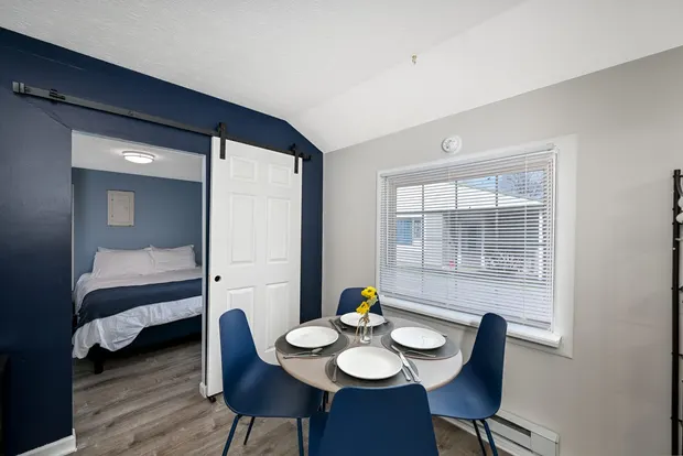 Queen bedroom with blue walls, seen through the doorway.