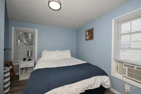 Light-blue bedroom with a queen bed and nautical accents.