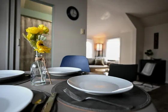 Small round dining table set for four with fresh flowers.