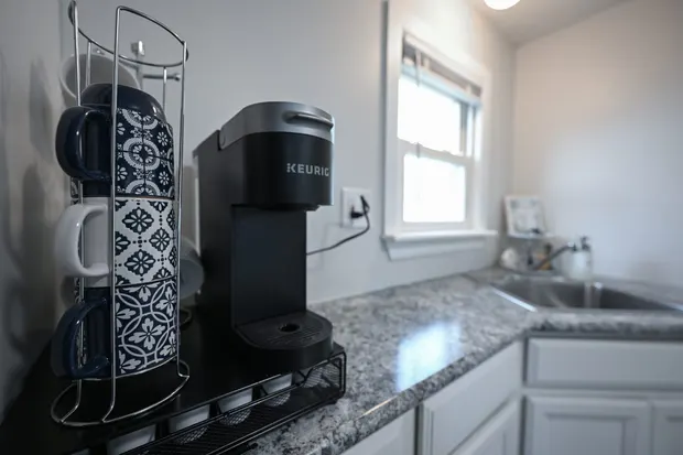 Coffee bar with a Keurig and mugs on the counter.