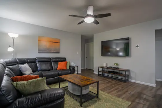 Living room with a large sectional sofa facing a wall-mounted TV.