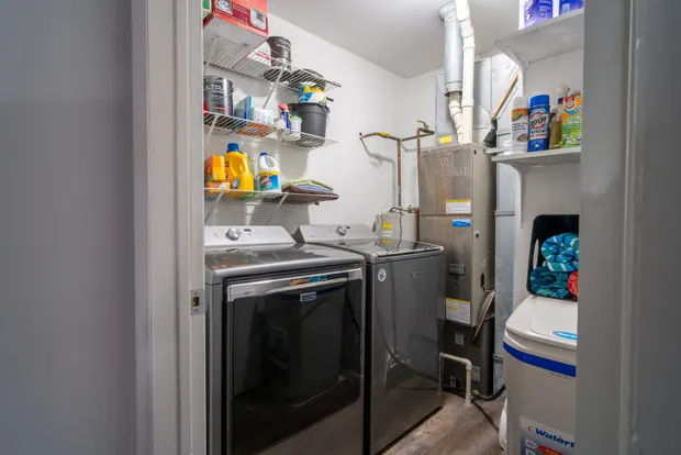 In-home washer and dryer with shelving of laundry supplies.