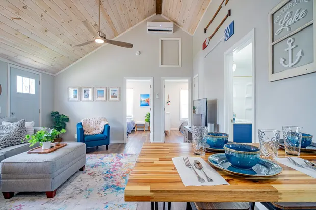 Open living and dining area with lake decor and a vaulted ceiling.