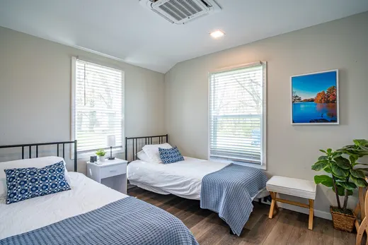 Bedroom with two twin beds, blue-and-white bedding, and windows.