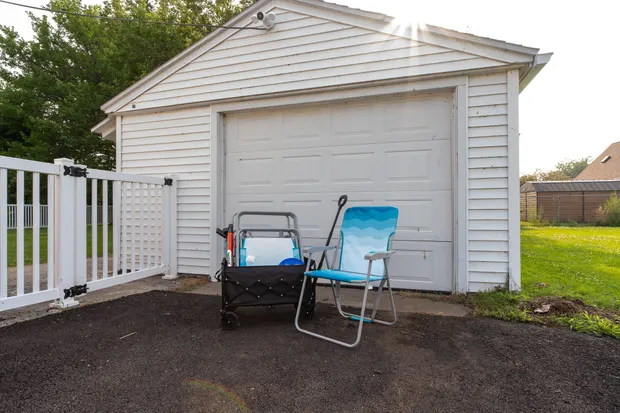 Beach wagon and folding chairs stored by the detached garage.