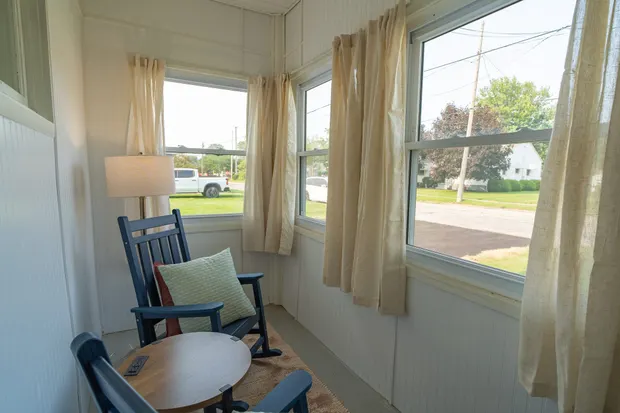 Sunroom rocking chairs beside a small table by the windows.