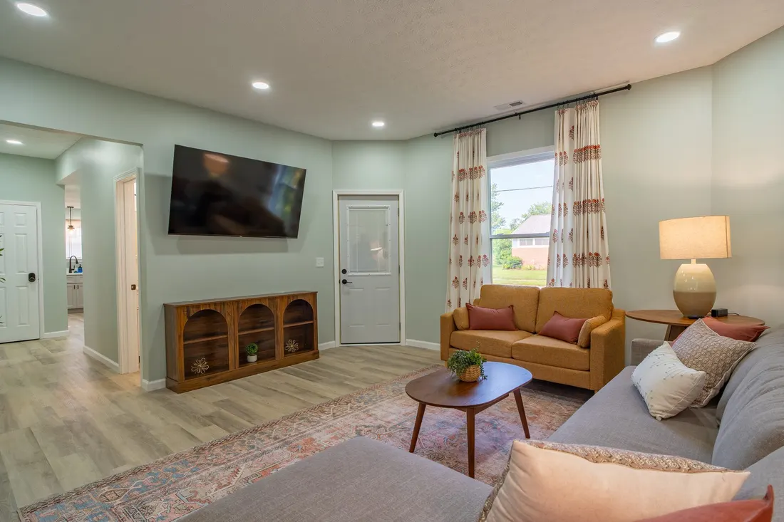 Living room with a sectional sofa and a patterned area rug.