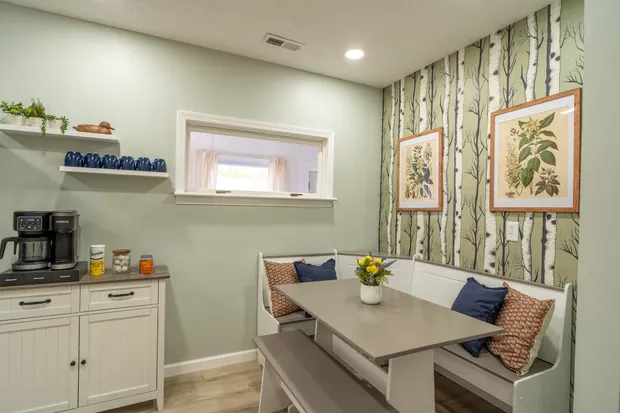 Built-in bench-seat dining nook beside a coffee station with a Keurig, sugar, and creamer.