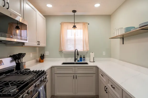 Kitchen counter and grey cabinetry with quartz countertops.