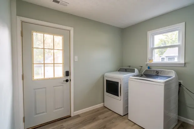 Laundry room with a full-size washer and dryer and a door to the backyard.