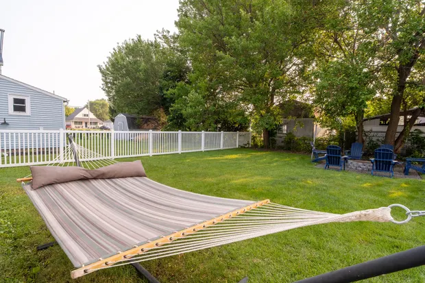 Rope hammock on the lawn with the fire-pit chairs beyond.