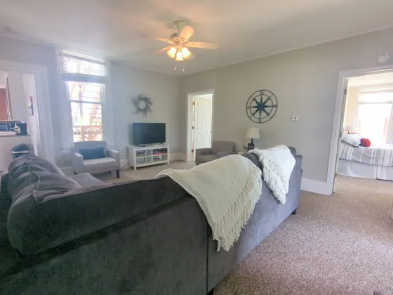 Downstairs living room with a large grey sectional and a TV.