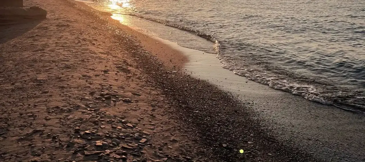 Lake Erie shoreline at sunset, with golden light on the water and an empty beach