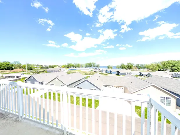 View from the balcony over rooftops toward a distant line of Lake Erie.