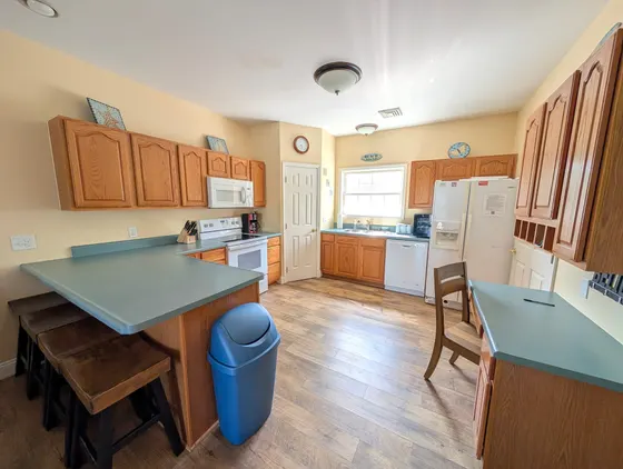 Kitchen with wood cabinets, blue countertops, and a window.