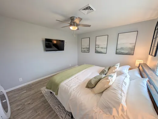 Third bedroom with a full bed, white bedding, and a green throw.