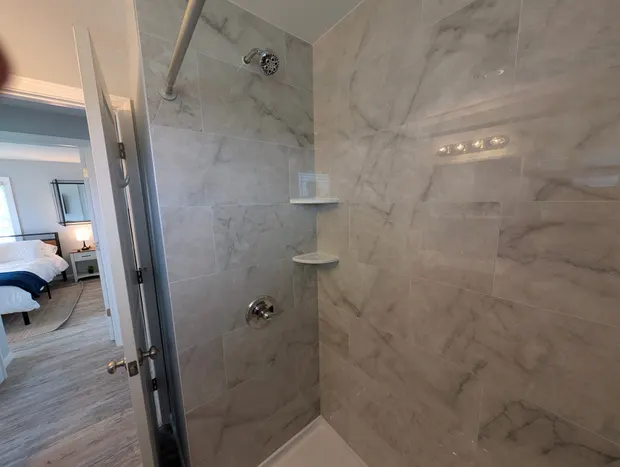 Bathroom with a grey marble-tiled walk-in shower.