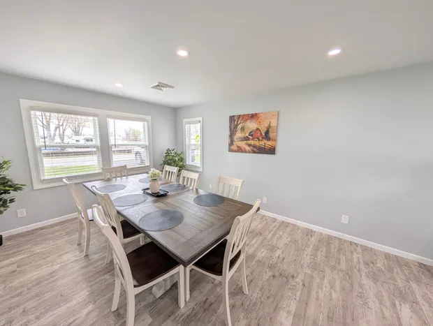 Dining table with six white chairs.