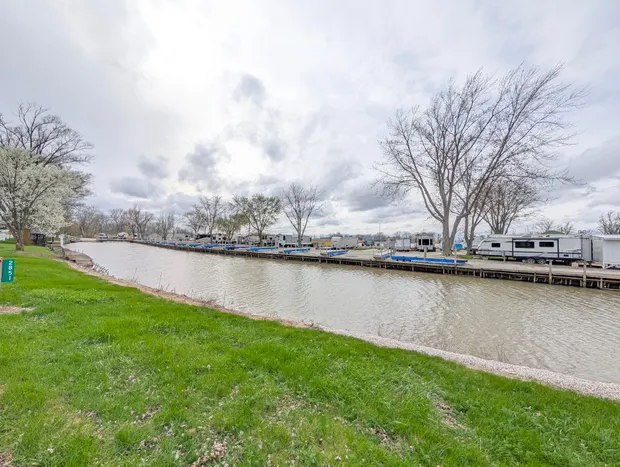 Waterfront RV park with docks and green grass by the river.