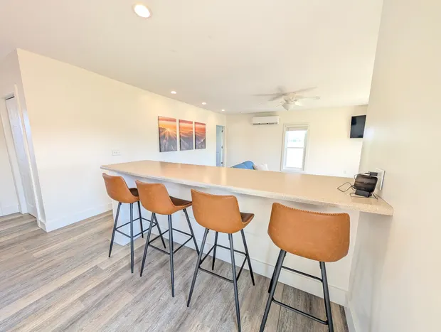 Four brown leather stools at a kitchen breakfast bar.