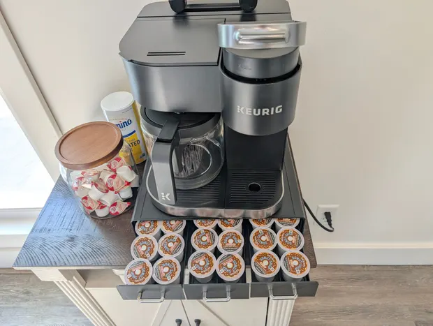 Keurig coffee station with a pod drawer, creamer, and sugar.