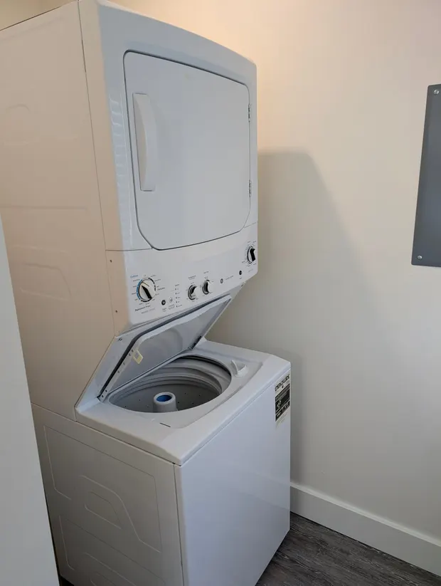 White stacked washer and dryer with the washer lid open.